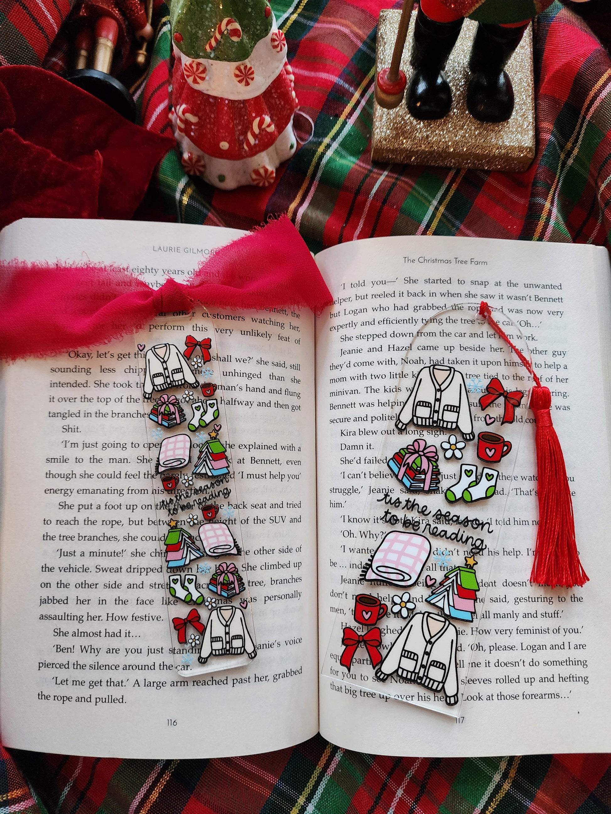 Decorative bookmarks with colorful designs on an open book against a plaid fabric background.
