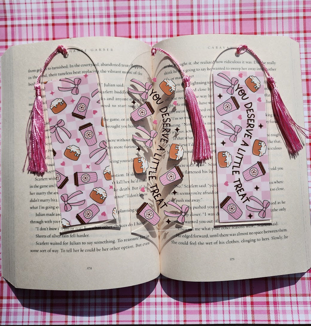 Open book with decorative bookmarks on a pink checkered surface